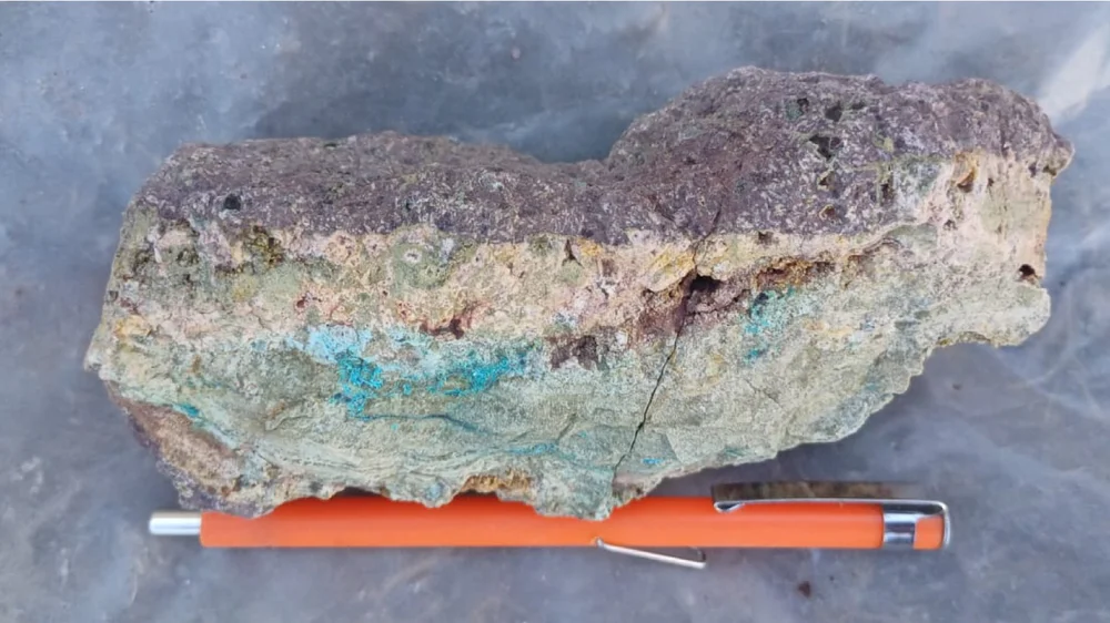 Large oxidised copper-bearing sample with orange pen for scale, collected at Las Estrellas